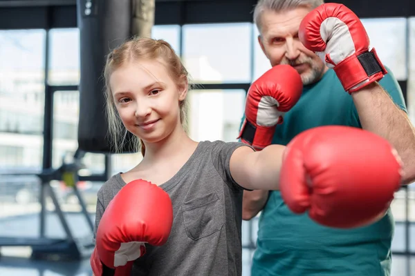 Preteen girl boxing with trainer. — Stock Photo