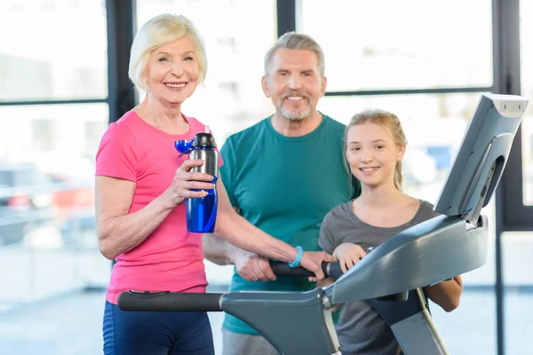 Seniorpaar und Mädchen auf Laufband — Stockfoto