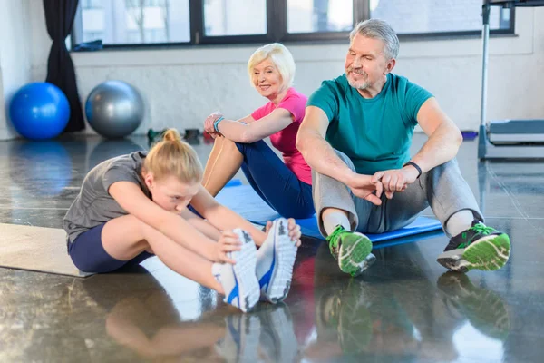 Old couple with girl in gym — Stock Photo