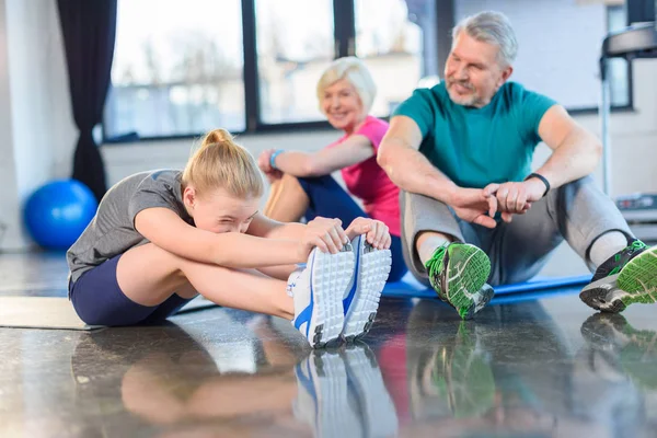 Pareja mayor con chica en el gimnasio - foto de stock