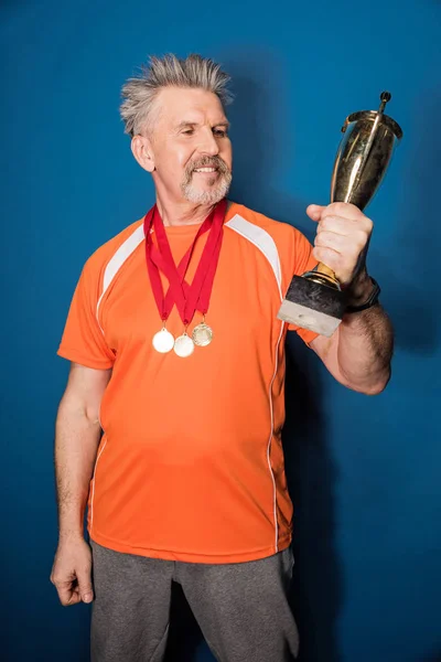 Deportista senior con trofeo - foto de stock