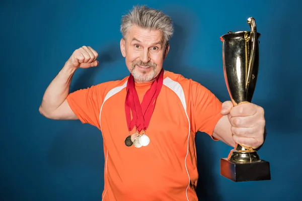 Esportista sênior com troféu — Fotografia de Stock