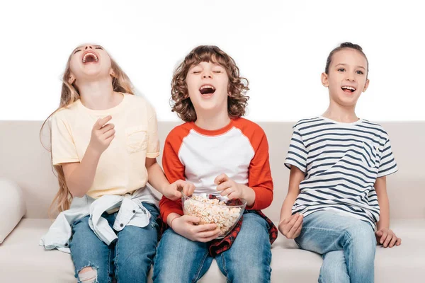 Bambini carini sul divano con popcorn — Foto stock