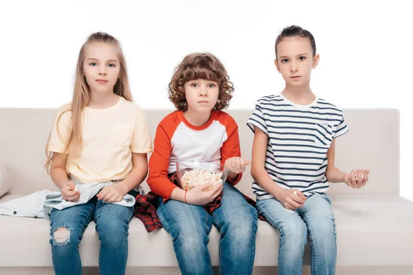 Niedliche Kinder auf der Couch mit Popcorn — Stockfoto