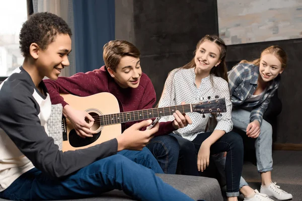 Подростки, играющие на акустической гитаре — стоковое фото