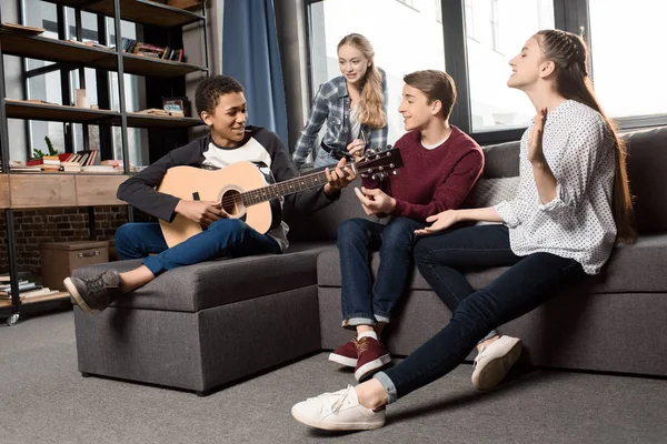 Adolescentes tocando guitarra acústica — Fotografia de Stock