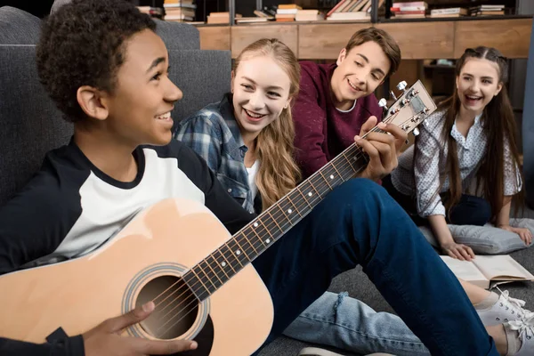 Adolescentes tocando guitarra acústica — Fotografia de Stock