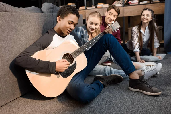 Подростки, играющие на акустической гитаре — стоковое фото