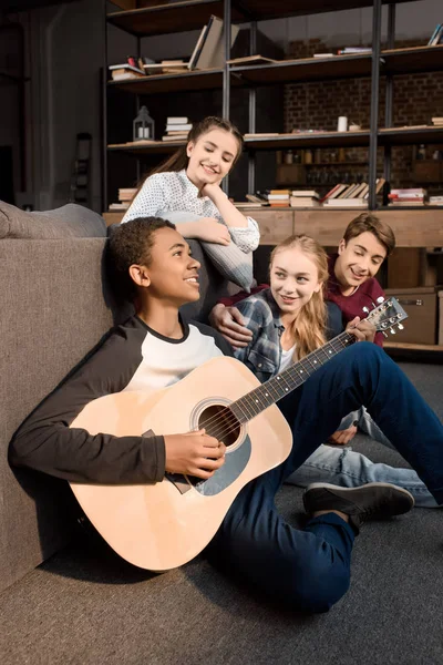 Adolescentes tocando guitarra acústica — Fotografia de Stock