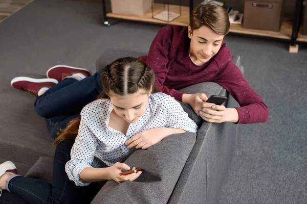 Подростковая пара, использующая смартфоны — стоковое фото