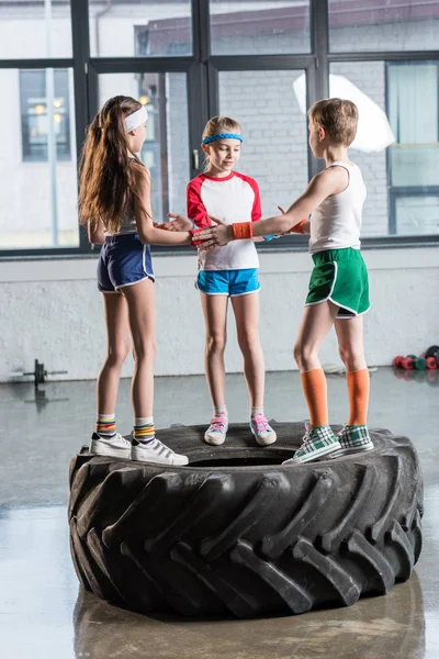 Niños en ropa deportiva jugando en el gimnasio - foto de stock