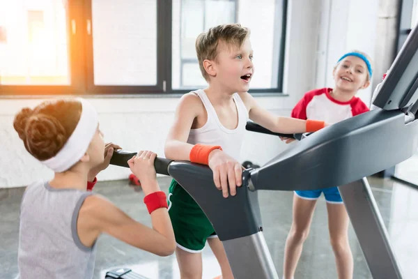 Niños en entrenamiento de ropa deportiva en la cinta de correr - foto de stock