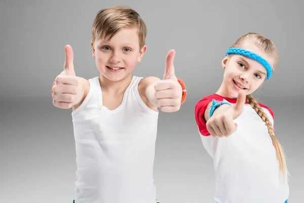 Niño y niña en ropa deportiva - foto de stock