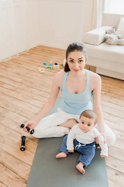 Femme avec bébé enfant utilisant des haltères — Photo de stock