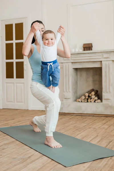 Madre con bebé niño practicando yoga - foto de stock