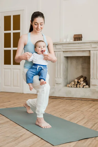 Mère avec bébé garçon pratiquant le yoga — Photo de stock