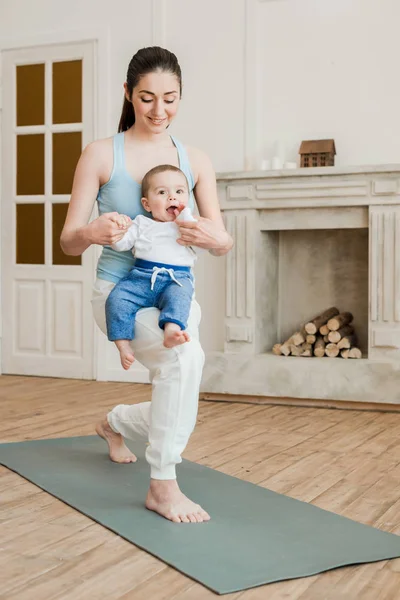 Mutter mit Baby praktiziert Yoga — Stockfoto