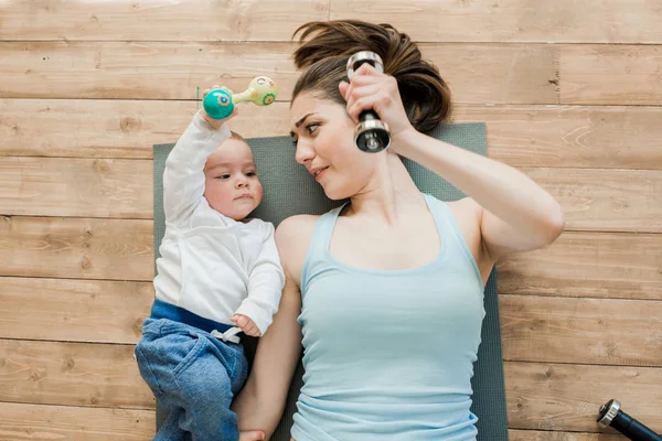 Mãe e bebê menino brincando com halteres — Fotografia de Stock