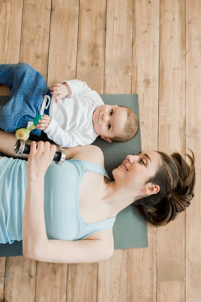 Madre y niño jugando con pesas - foto de stock