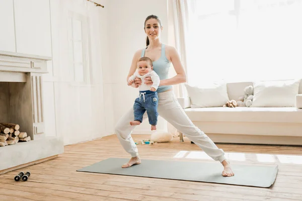 Mutter mit Baby praktiziert Yoga — Stockfoto