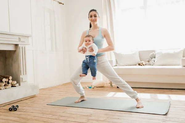 Madre con bebé niño practicando yoga - foto de stock