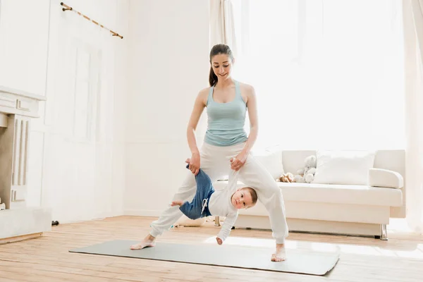 Madre con bebé niño practicando yoga - foto de stock