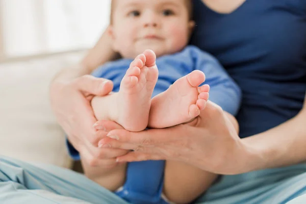 Pies de niño en las manos de la madre - foto de stock