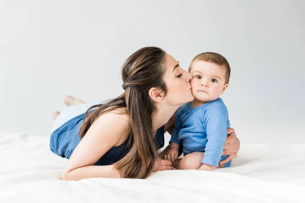 Madre joven con el niño acostado en la cama - foto de stock