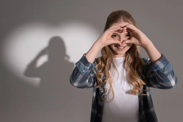 Chica con corazón en forma de sombra - foto de stock