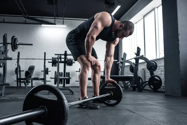 Exausto fisiculturista segurando barbell no ginásio — Fotografia de Stock