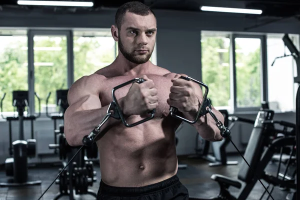 Treinamento fisiculturista sem camisa com máquina de peso — Fotografia de Stock