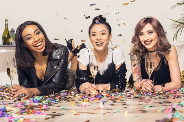 Девушки лежат на полу с бокалами шампанского — стоковое фото