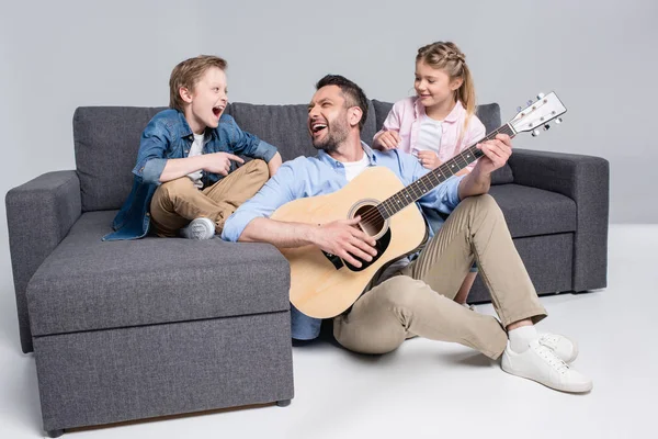 Familia feliz tocando en la guitarra - foto de stock