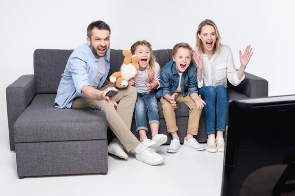 Familie schaut fern, während sie auf dem Sofa sitzt — Stockfoto