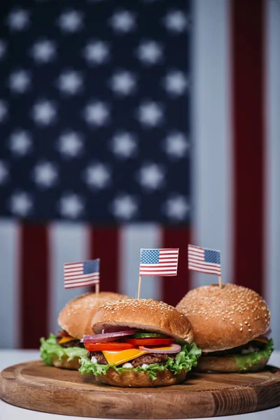 Cheeseburgers with little american flags — Stock Photo