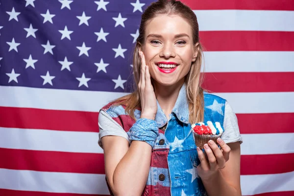 Woman with cupcake decorated with American flag — Stock Photo