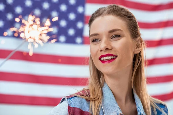 Smiling woman with sparkler — Stock Photo