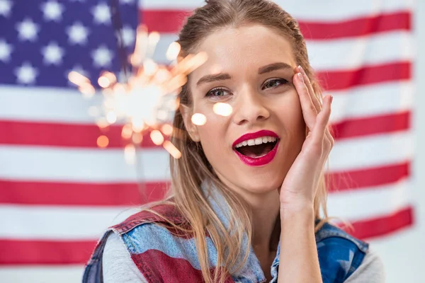 Smiling woman with sparkler — Stock Photo