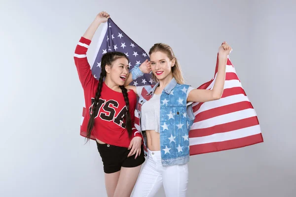 Niñas de pie y con bandera de Estados Unidos - foto de stock