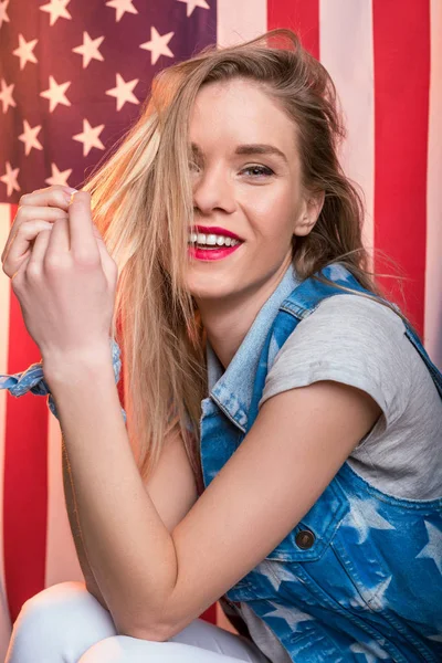 Mujer posando frente a la bandera de EE.UU. - foto de stock