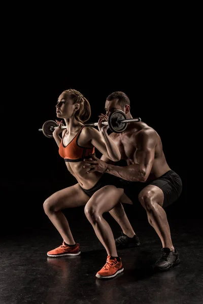 Couple exercising with barbell — Stock Photo