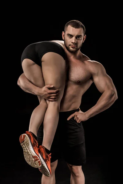 Спортивный мужчина держит женщину — стоковое фото