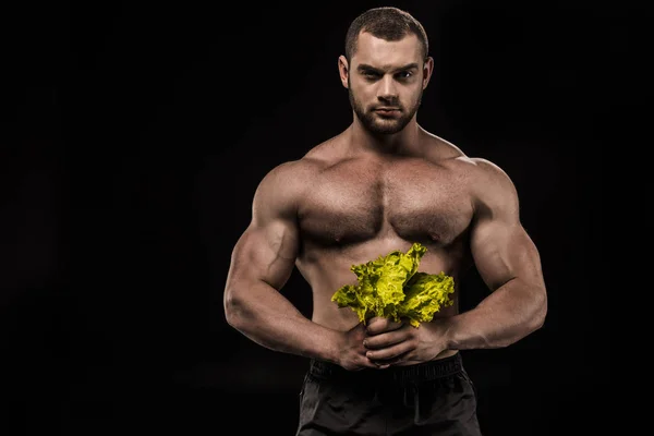 Shirtless sportsman holding salad leaves — Stock Photo