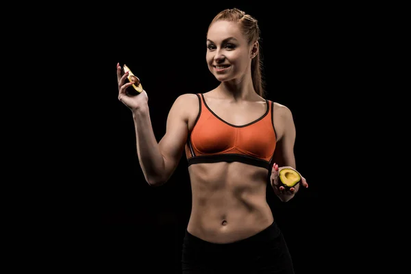 Sporty girl holding avocado — Stock Photo