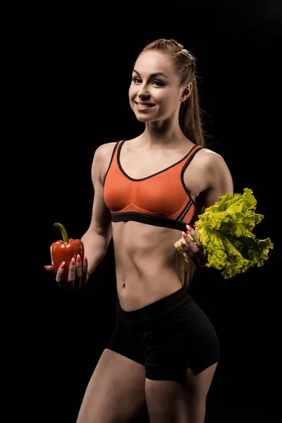 Спортсменка тримає болгарський перець і салат — стокове фото