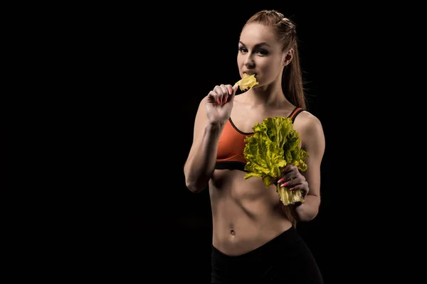 Sportswoman comer lechuga ensalada hojas - foto de stock