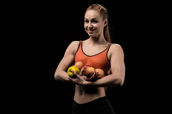Sonriente atleta caucásica sosteniendo manzanas - foto de stock