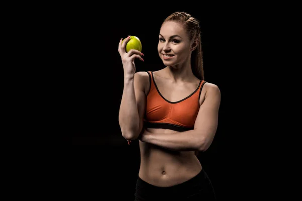 Smiling caucasian sportswoman holding apple — Stock Photo