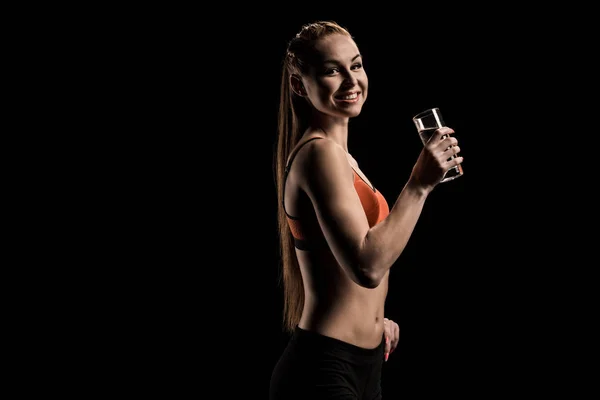 Улыбающаяся спортсменка держит стакан воды — стоковое фото