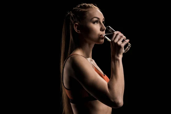 Mujer deportiva beber agua de vidrio - foto de stock